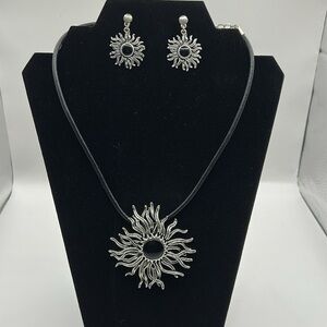 Silvertone sunburst necklace and earring set.  Leather strap.